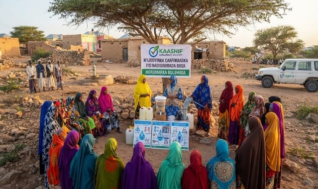 Women gathered under a tree for a KDI hygiene awareness and water treatment session